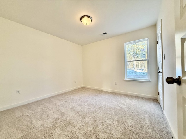 empty room with light carpet, visible vents, and baseboards