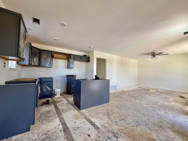 kitchen featuring a ceiling fan, visible vents, dark brown cabinetry, and baseboards