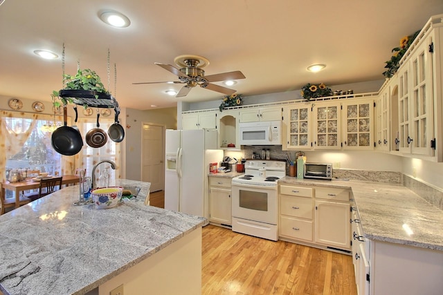 kitchen with sink, ceiling fan, light stone counters, white appliances, and light hardwood / wood-style flooring