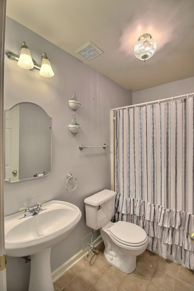 bathroom with tile patterned flooring, curtained shower, and toilet