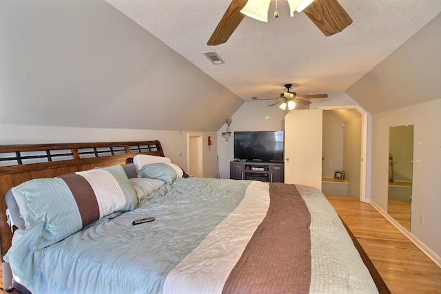 bedroom featuring hardwood / wood-style floors, a textured ceiling, vaulted ceiling, and ceiling fan