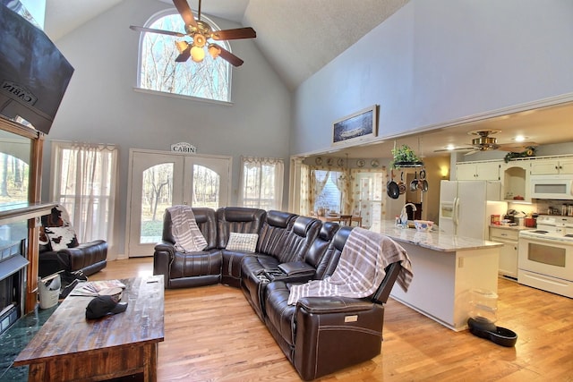 living room featuring french doors, sink, high vaulted ceiling, and light wood-type flooring