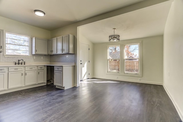 kitchen featuring sink, decorative light fixtures, dark wood-type flooring, and decorative backsplash