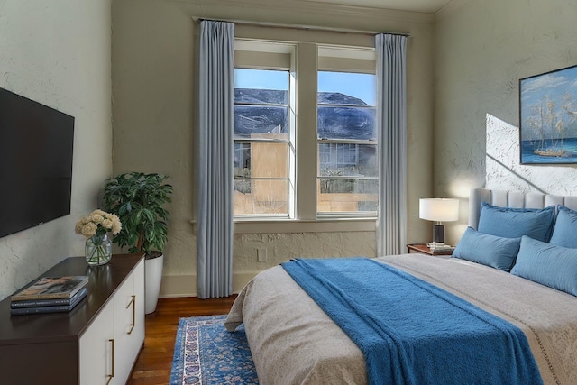 bedroom with ornamental molding and dark hardwood / wood-style floors