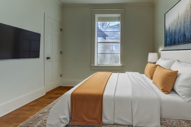 bedroom with hardwood / wood-style flooring and crown molding