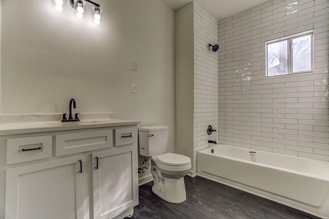 full bathroom featuring tiled shower / bath combo, vanity, hardwood / wood-style floors, and toilet