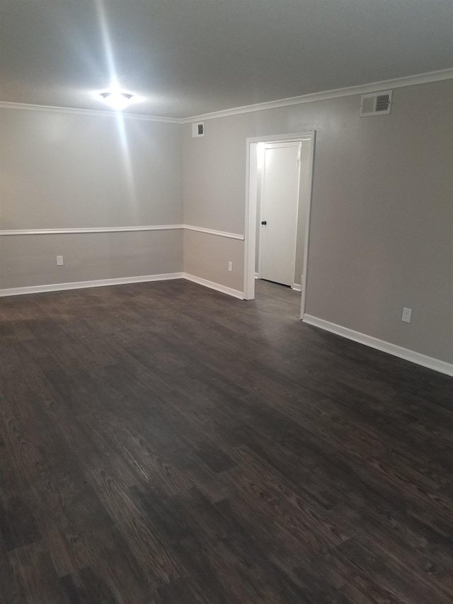 unfurnished room featuring ornamental molding and dark wood-type flooring