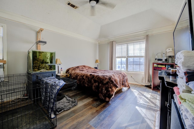 bedroom with crown molding, ceiling fan, hardwood / wood-style floors, vaulted ceiling, and a raised ceiling