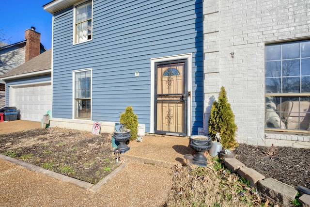 view of exterior entry with a garage