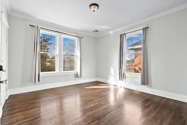 empty room featuring ornamental molding, plenty of natural light, and dark hardwood / wood-style floors