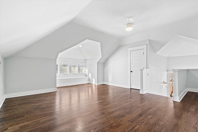 additional living space featuring vaulted ceiling and dark hardwood / wood-style floors