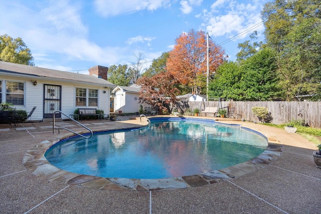 view of swimming pool featuring fence, a fenced in pool, and a patio