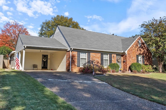 view of front of home featuring driveway, brick siding, an attached carport, roof with shingles, and a front yard