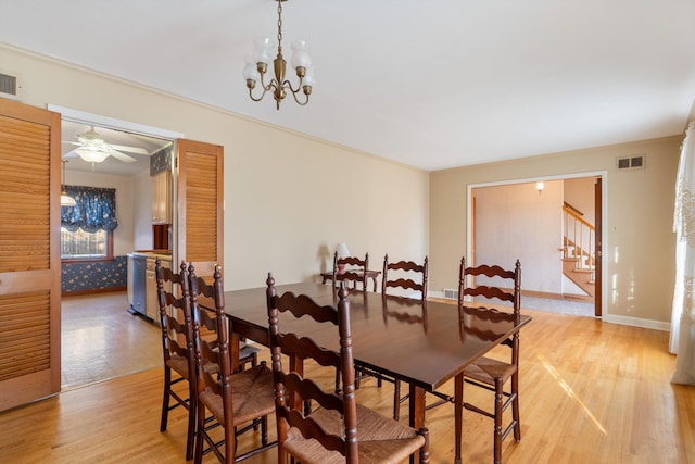 dining area with visible vents, baseboards, light wood-style flooring, stairway, and a chandelier