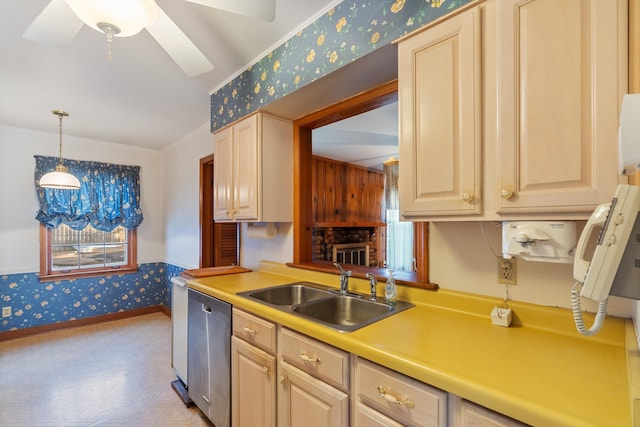 kitchen with light countertops, a sink, dishwasher, baseboards, and wallpapered walls