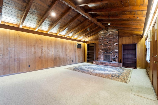 unfurnished living room with vaulted ceiling with beams, wooden ceiling, wooden walls, a fireplace, and carpet flooring