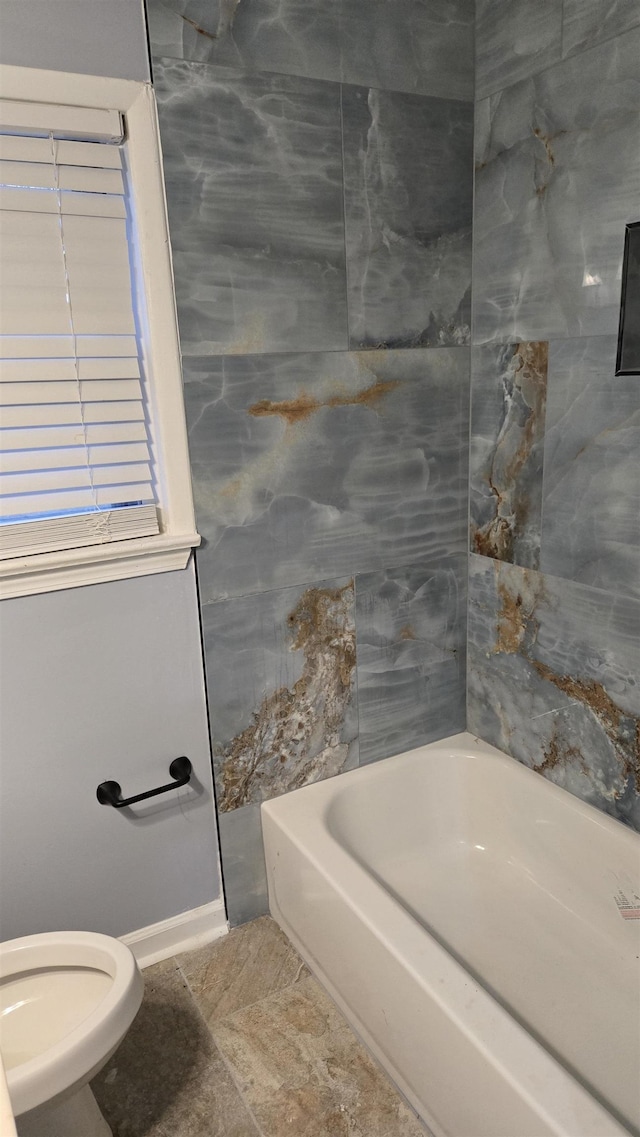 bathroom featuring washtub / shower combination and toilet