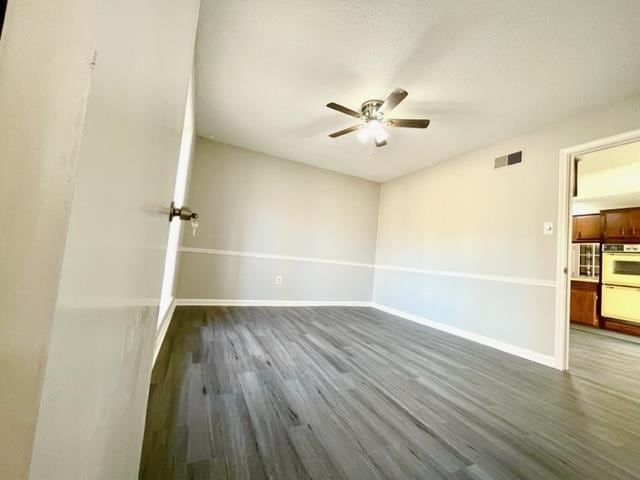 empty room with hardwood / wood-style floors and ceiling fan