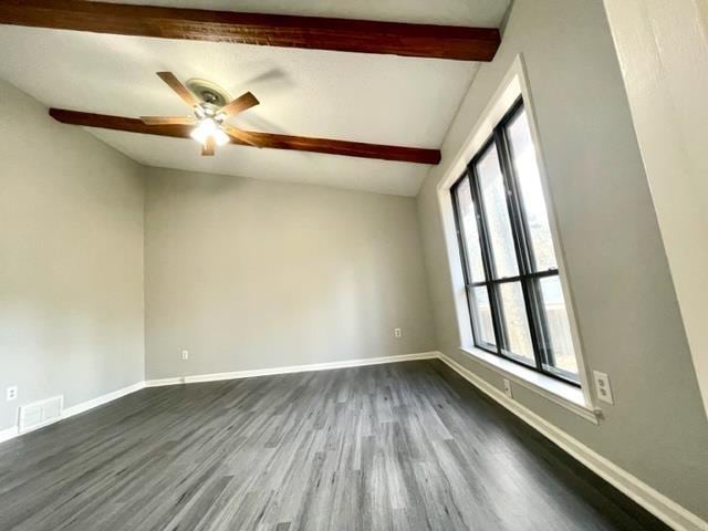 unfurnished room featuring ceiling fan, dark hardwood / wood-style floors, and beamed ceiling