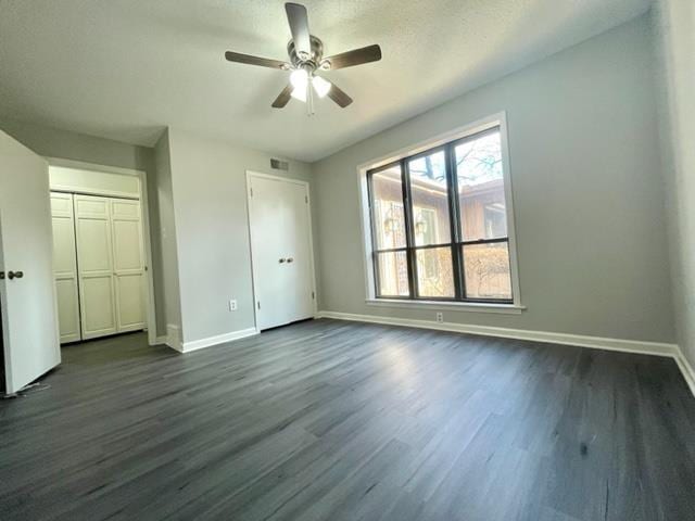 unfurnished bedroom featuring dark hardwood / wood-style floors and ceiling fan