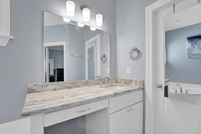 bathroom with vanity and a bath