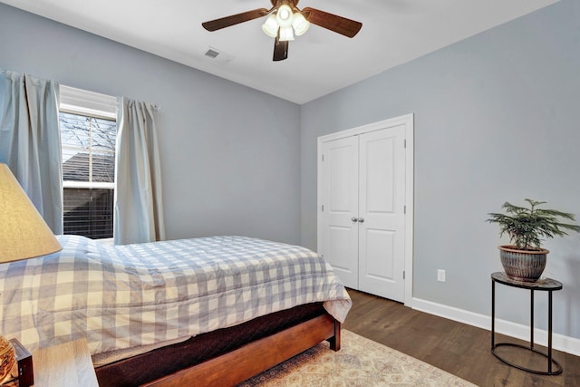 bedroom with dark wood-type flooring, ceiling fan, and a closet