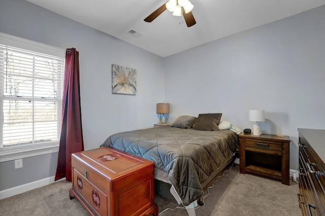 carpeted bedroom featuring multiple windows and ceiling fan