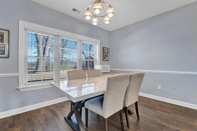 dining area featuring dark hardwood / wood-style floors and a chandelier