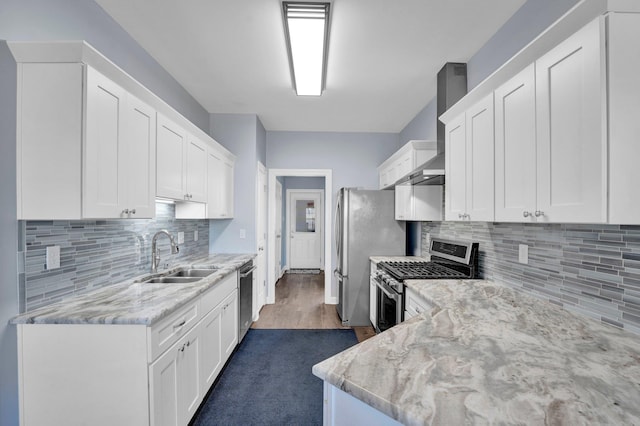 kitchen with stainless steel appliances, light stone countertops, sink, and white cabinets