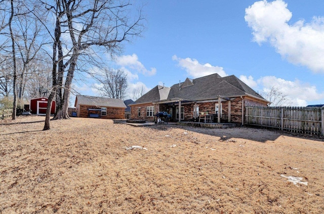 rear view of house with a storage shed