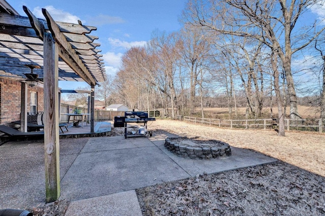 view of patio with a wooden deck, a pergola, and an outdoor fire pit