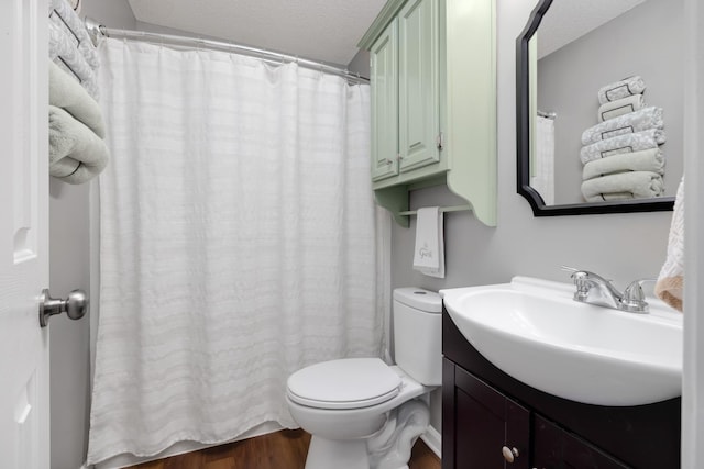 bathroom featuring vanity, wood-type flooring, a textured ceiling, and toilet