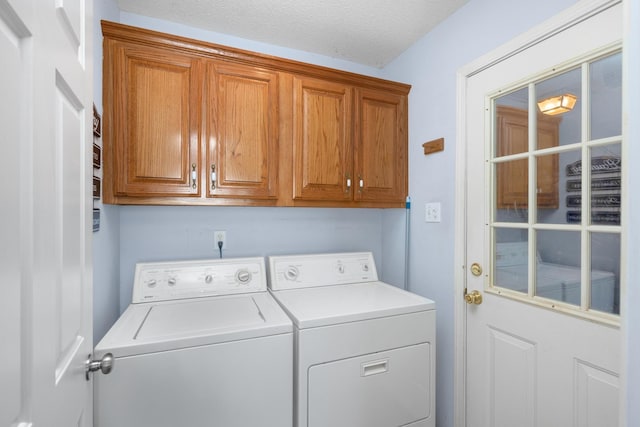 laundry room featuring cabinets, washer and dryer, and a textured ceiling