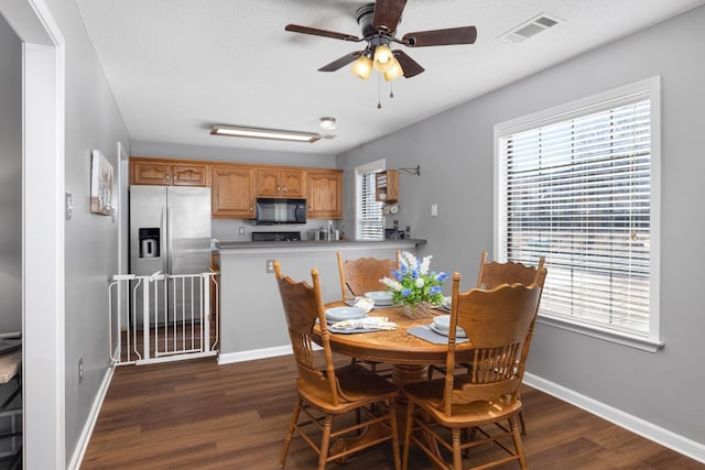 dining room featuring dark wood-type flooring, ceiling fan, and a wealth of natural light