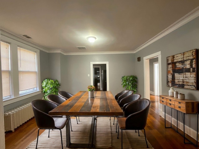 dining room with ornamental molding, radiator, and wood-type flooring