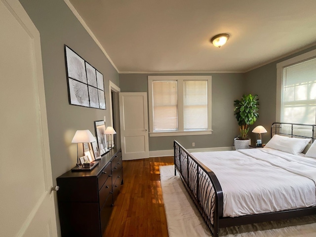 bedroom featuring crown molding, hardwood / wood-style flooring, and multiple windows