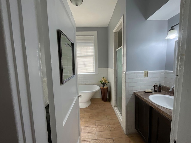 bathroom featuring vanity, independent shower and bath, and tile walls