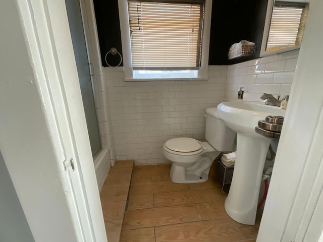 bathroom with tile walls, sink, and toilet