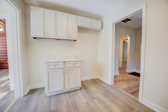 kitchen with light wood-type flooring and white cabinets