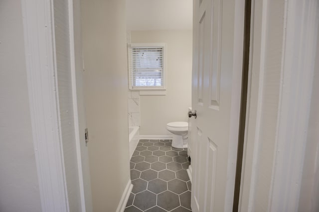 bathroom with a washtub and toilet