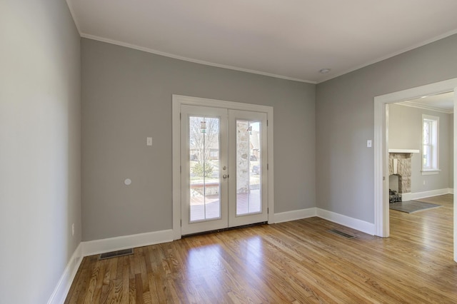 doorway featuring crown molding, light hardwood / wood-style floors, and french doors