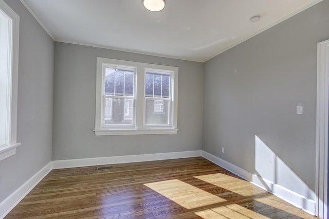 spare room with ornamental molding and dark hardwood / wood-style floors