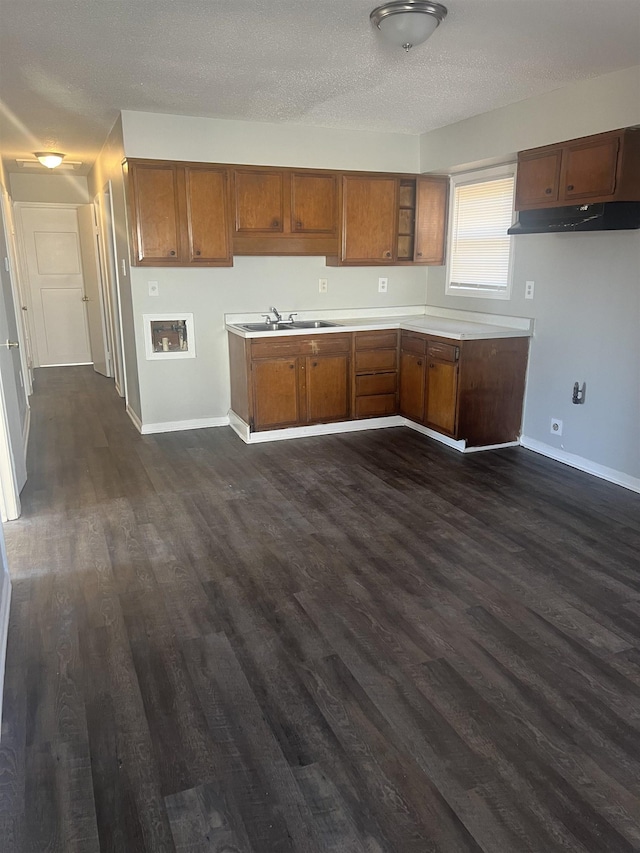 kitchen featuring dark hardwood / wood-style flooring, sink, and a textured ceiling