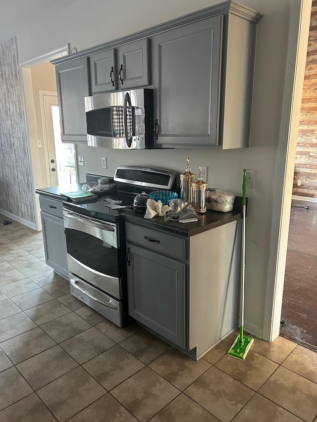 kitchen featuring appliances with stainless steel finishes, dark countertops, and gray cabinetry