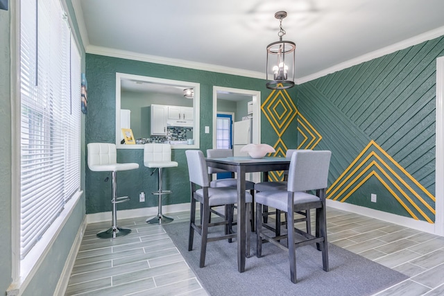 dining space with ornamental molding and a healthy amount of sunlight