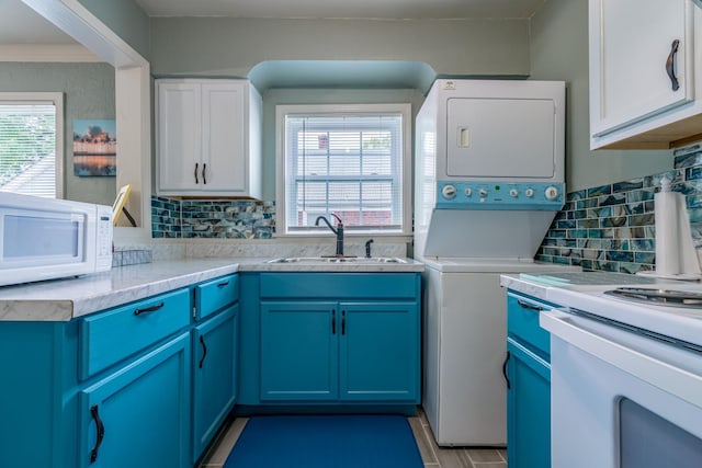 laundry area with stacked washer and dryer and sink