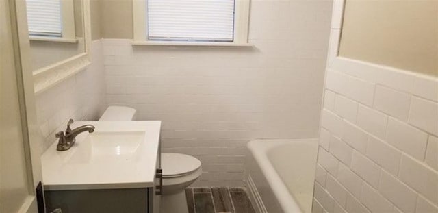 bathroom with vanity, a bathtub, and toilet