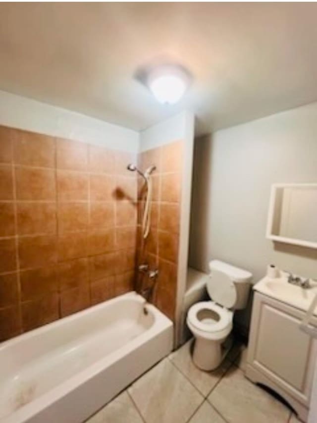 full bathroom featuring tiled shower / bath, vanity, toilet, and tile patterned flooring