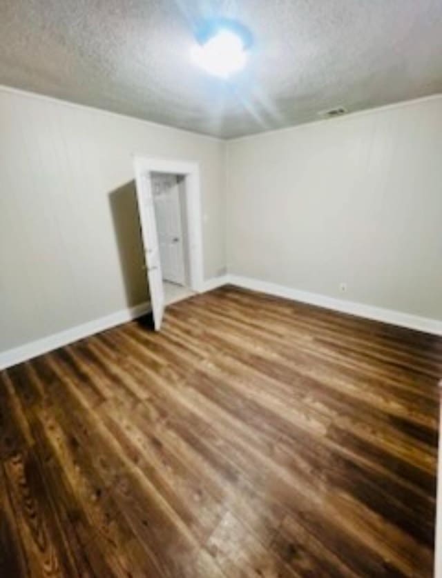 unfurnished bedroom featuring dark hardwood / wood-style floors and a textured ceiling