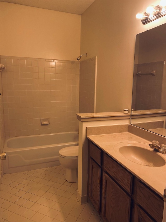 full bathroom featuring tile patterned flooring, tiled shower / bath, vanity, and toilet